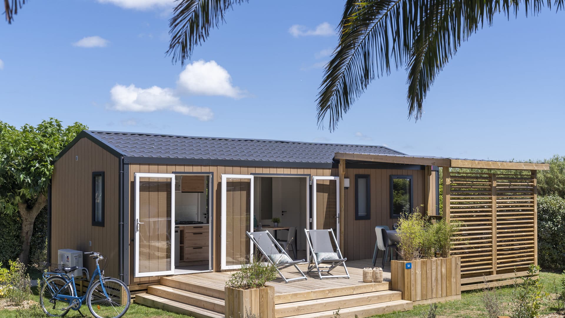 Chalet en bois avec terrasse et chaises longues.