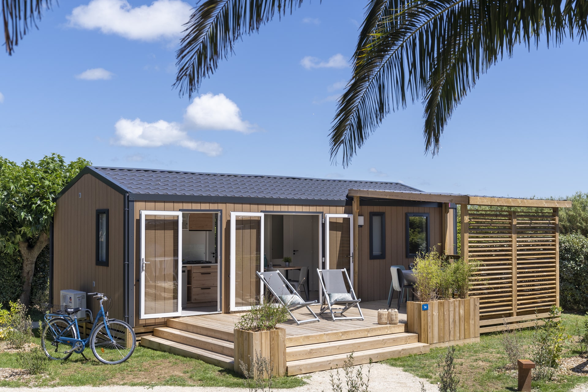 Chalet en bois avec terrasse et chaises longues.