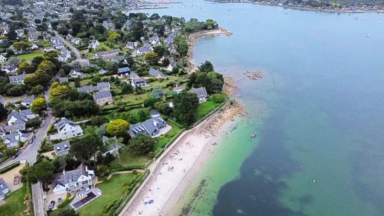 Vue aérienne de la côte bretonne, plage et maisons.