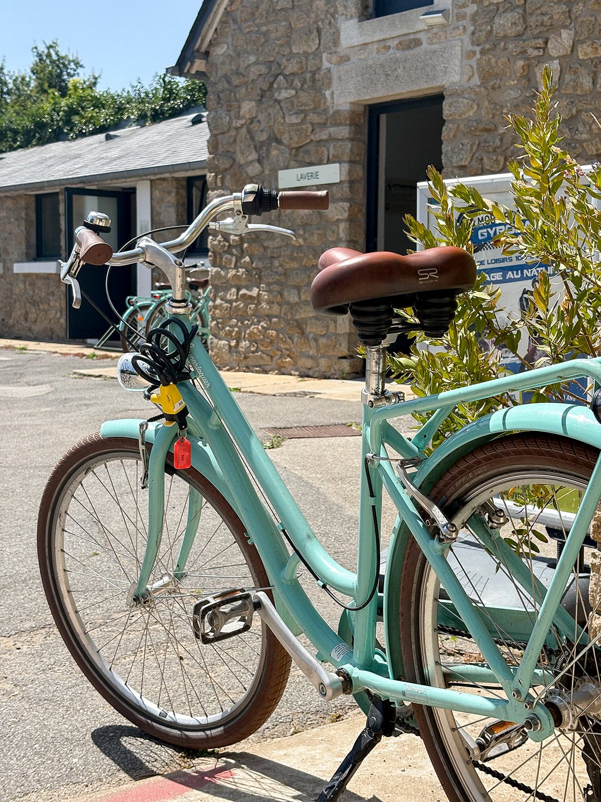 Vélo bleu vintage stationné devant une laverie.